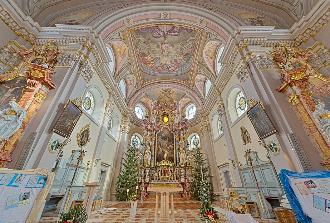 Innenansicht einer Kirche mit Altar, Deckenfresko und Weihnachtsdekoration