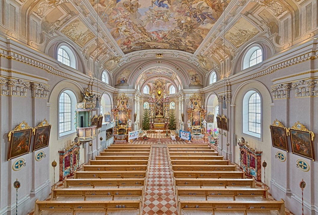 Innenansicht einer Kirche mit Bänken, Altar und kunstvoller Deckenmalerei