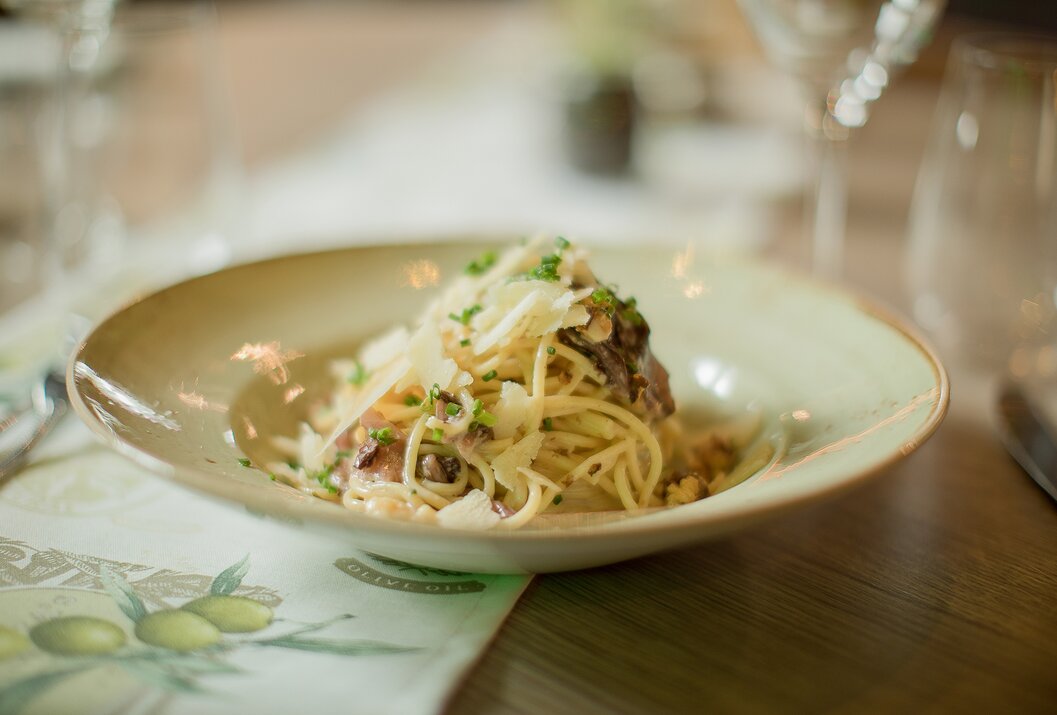 Teller mit Spaghetti Carbonara und Käse auf einem Tisch