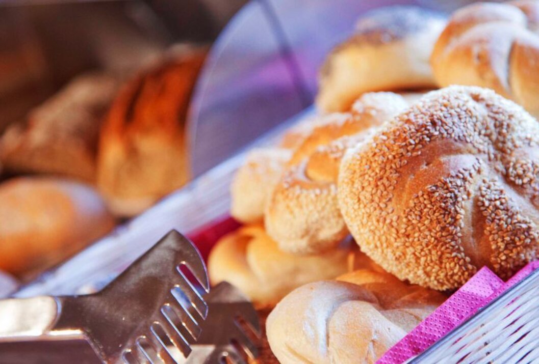 Brötchen mit Sesam in einem Korb mit Zange