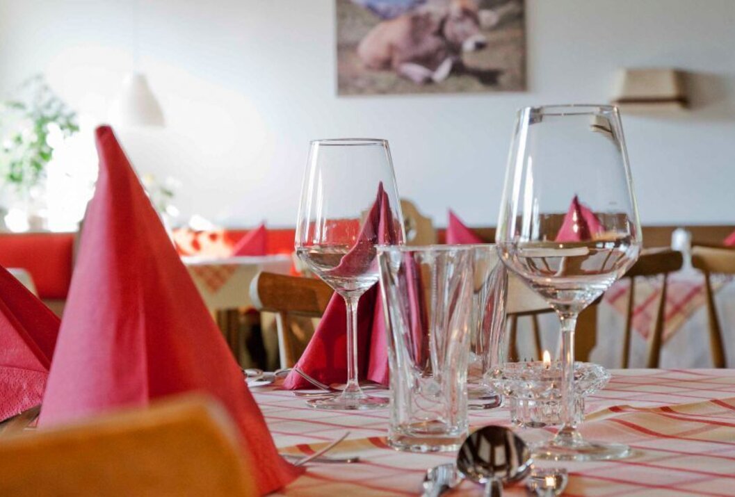 Gedeckter Tisch mit Weingläsern, Servietten und Besteck in einem Restaurant oder Hotel