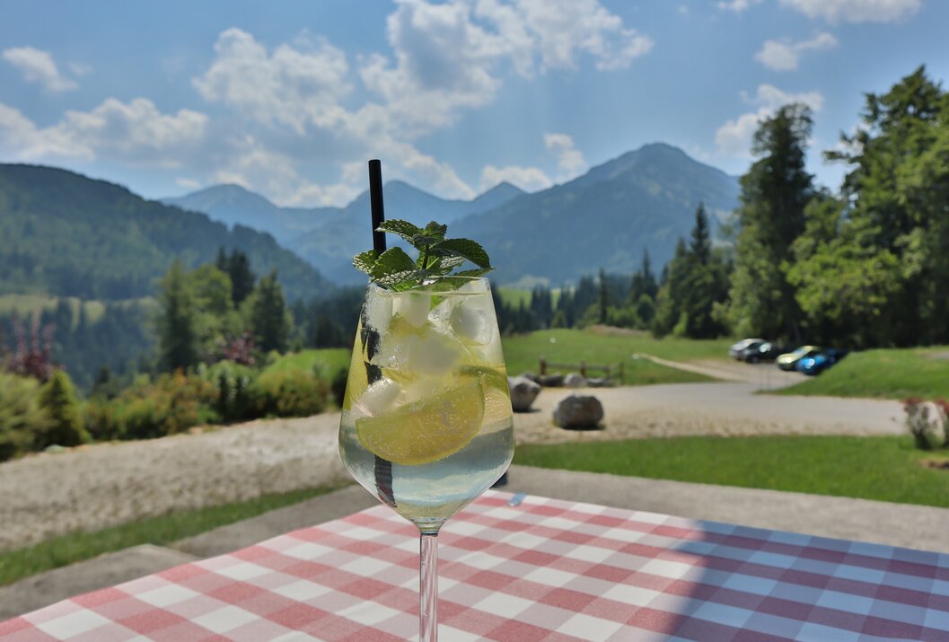 Cocktail mit Minze vor Berglandschaft