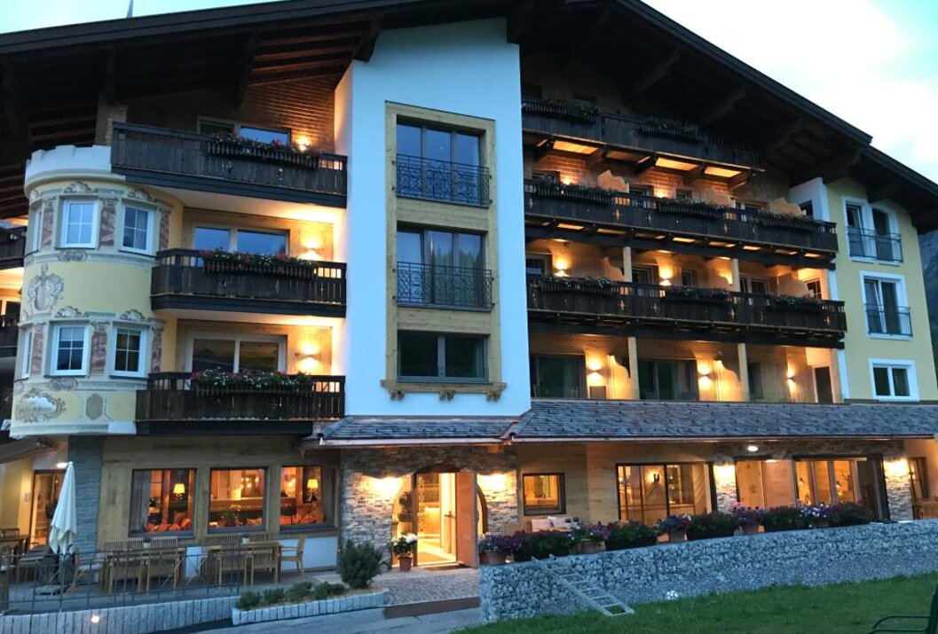 Hotelgebäude mit Balkonen und Holzverzierungen bei Dämmerung