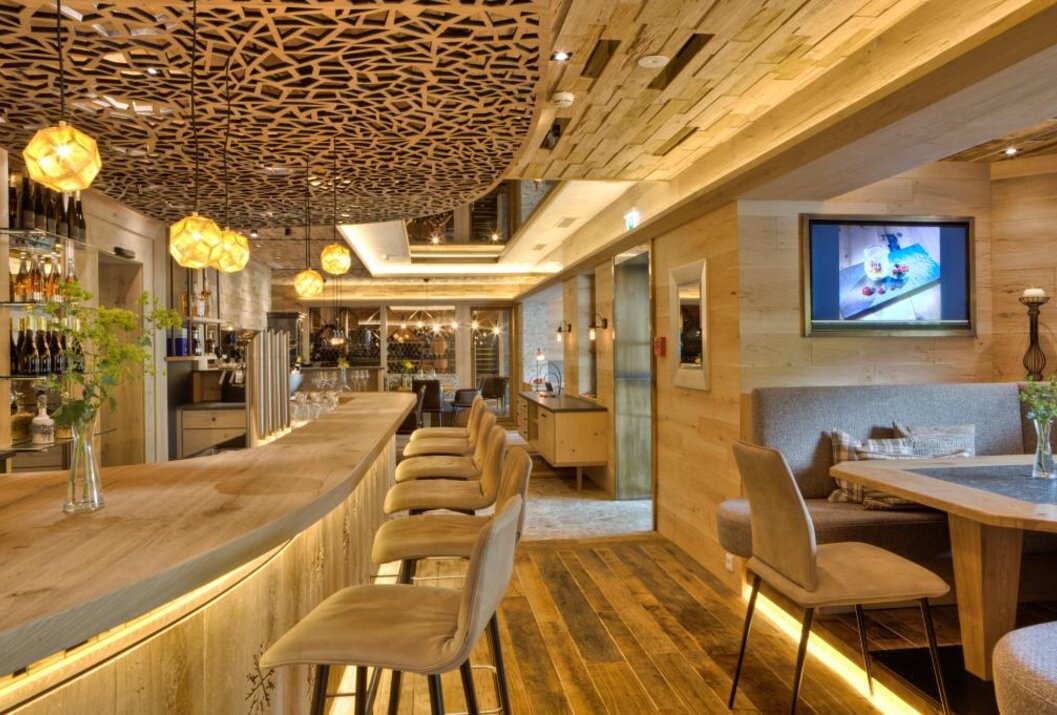 Innenansicht eines Restaurants mit Bar, Holzboden und dekorativer Decke