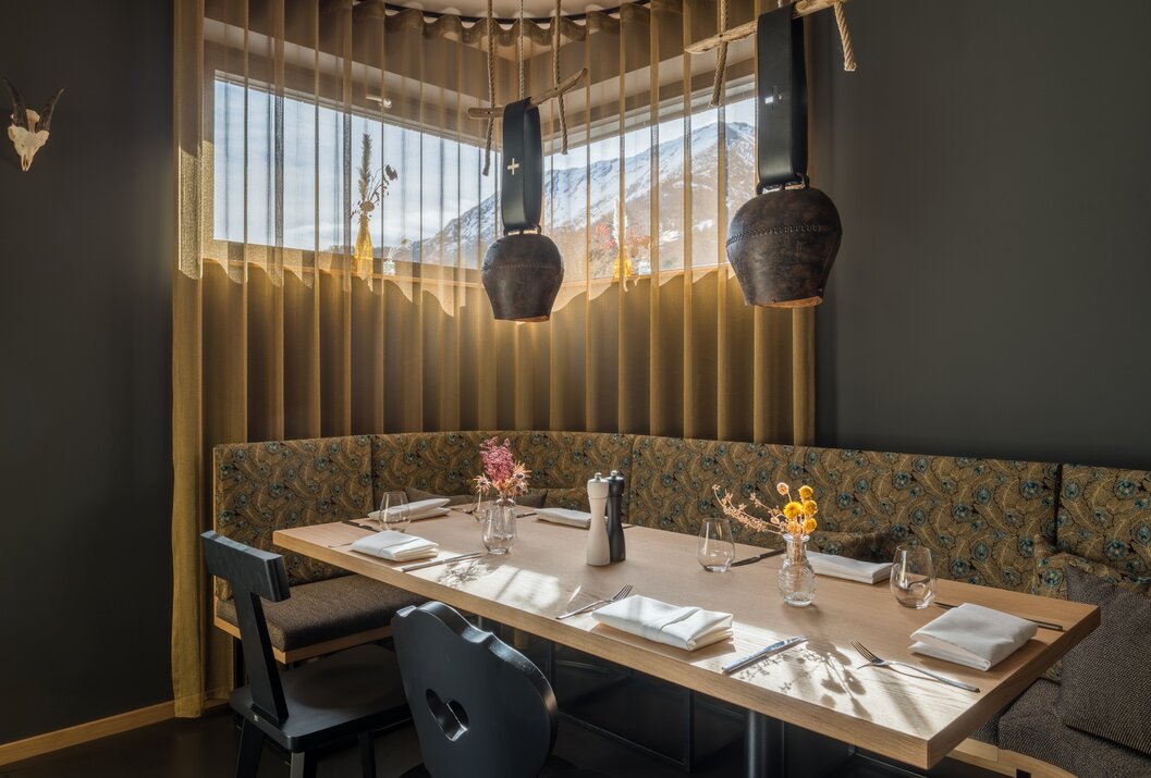 Restaurant mit gedecktem Tisch, Kuhglocken-Lampen und Bergblick