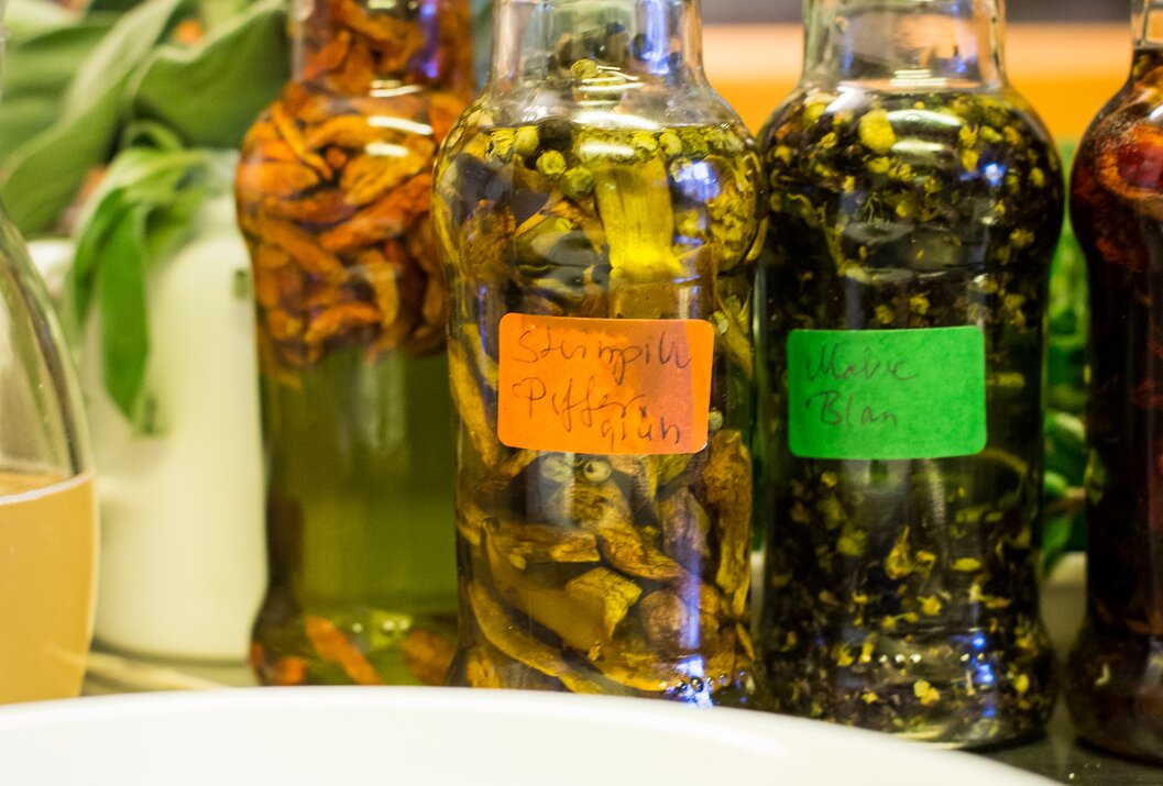 Glasflaschen mit Kräuterölen stehen auf einem Tisch