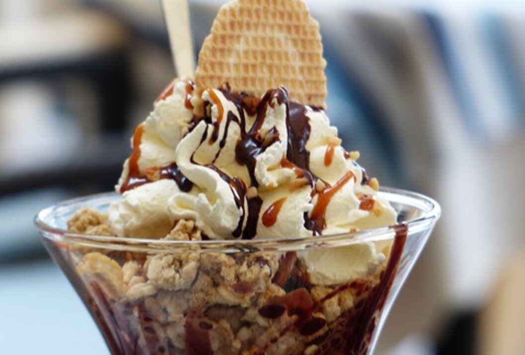 Eisbecher mit Sahne, Waffel und Schokosoße im Glas