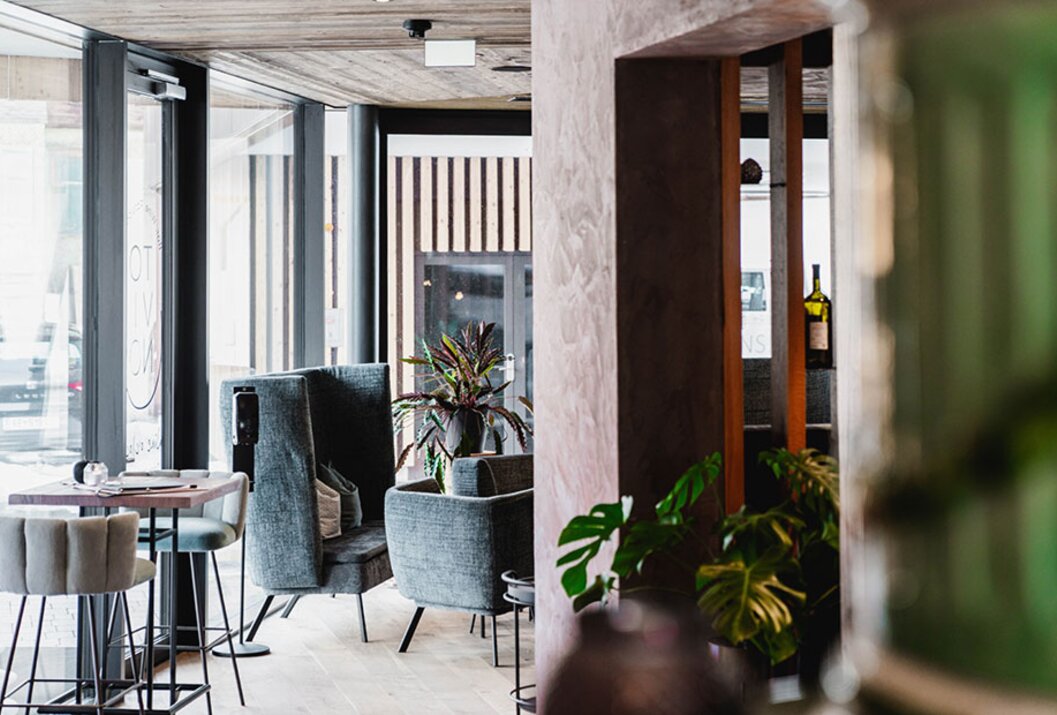Innenansicht eines modernen Restaurants mit Sesseln und Pflanzen