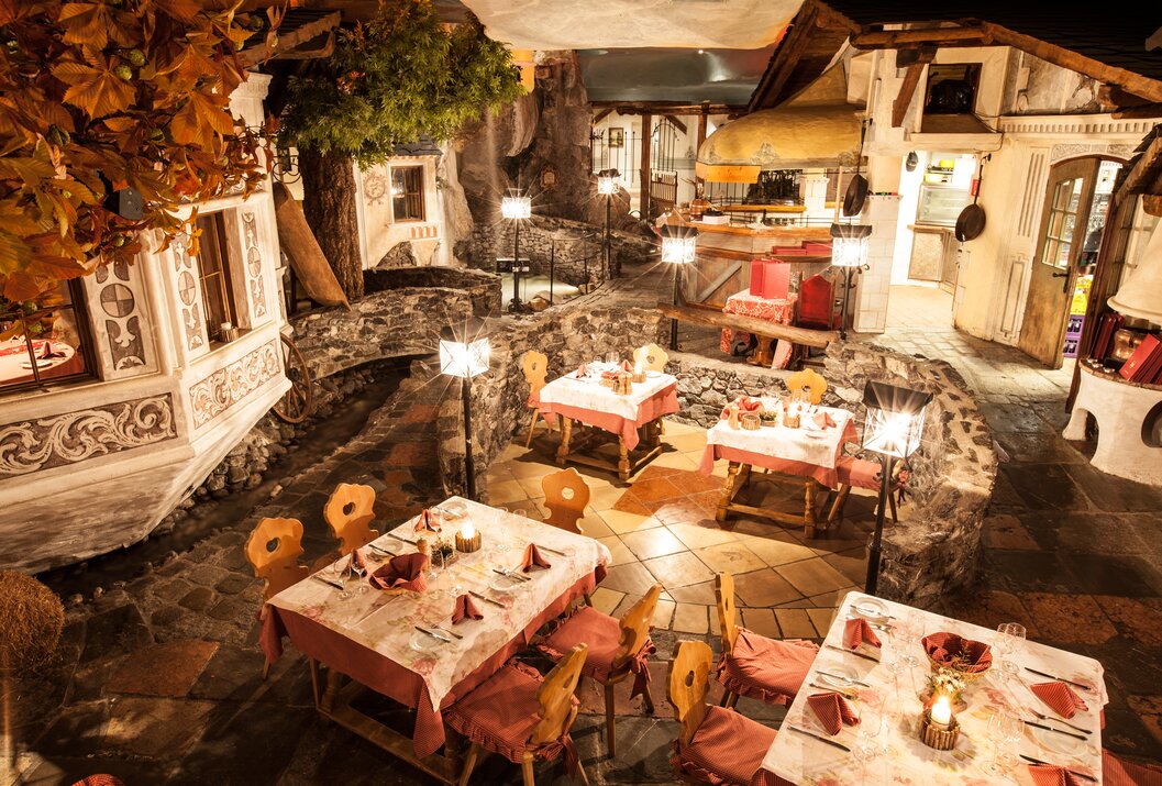 Rustikales Restaurant mit gedeckten Tischen und ungewöhnlicher Dekoration
