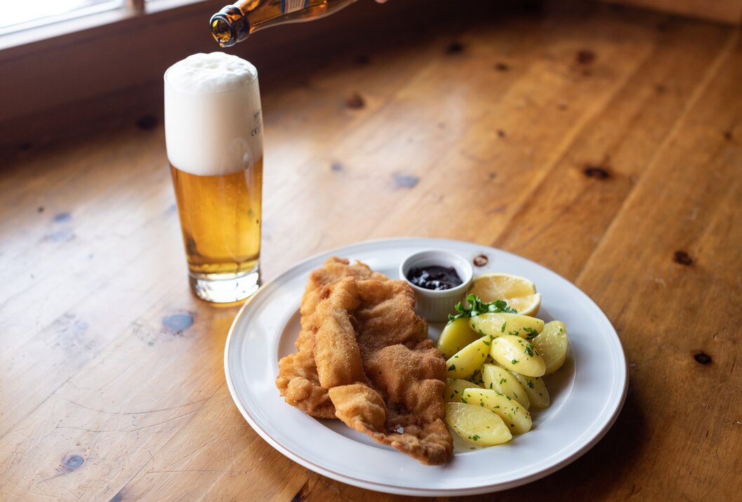 Wiener Schnitzel mit Kartoffeln, Preiselbeeren und Zitrone, dazu ein Glas Bier