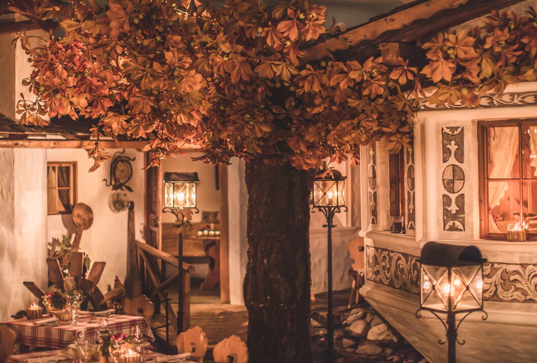 Rustikales Haus mit Herbstlaub, Laternen und gemütlicher Beleuchtung