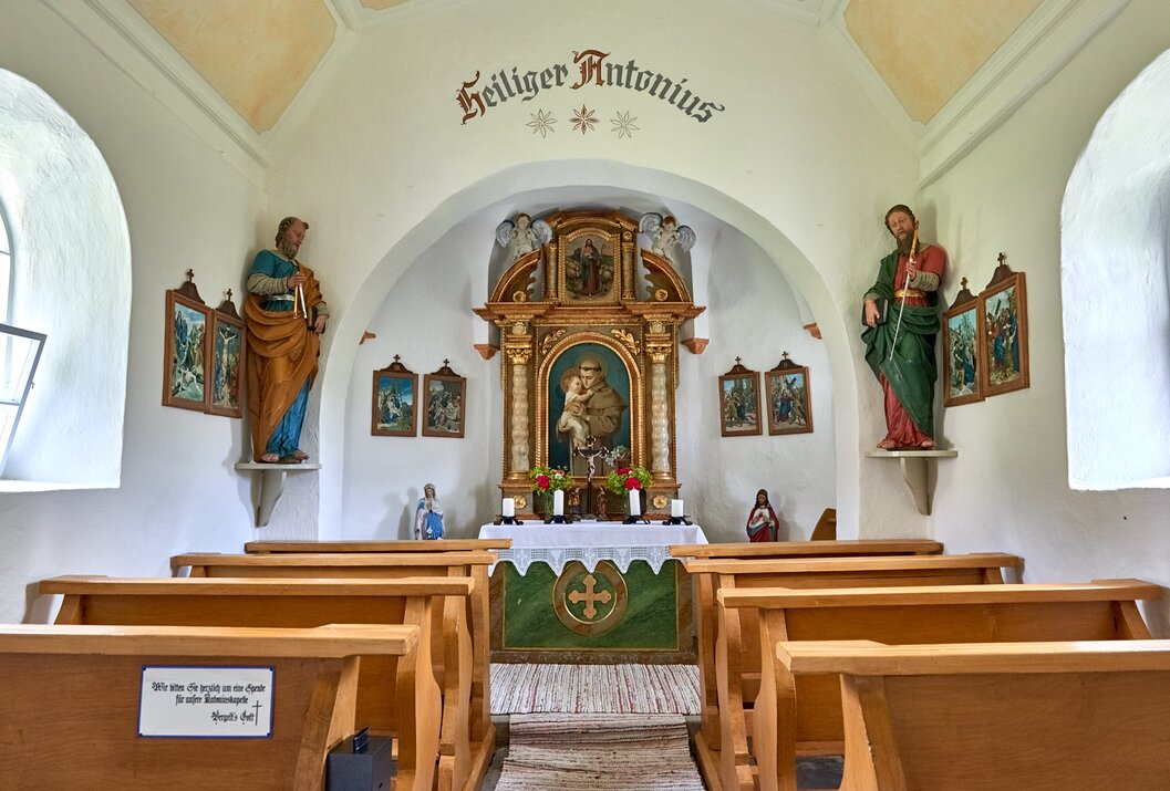 Innenansicht einer kleinen Kapelle mit Altar, Heiligenfiguren und Bänken