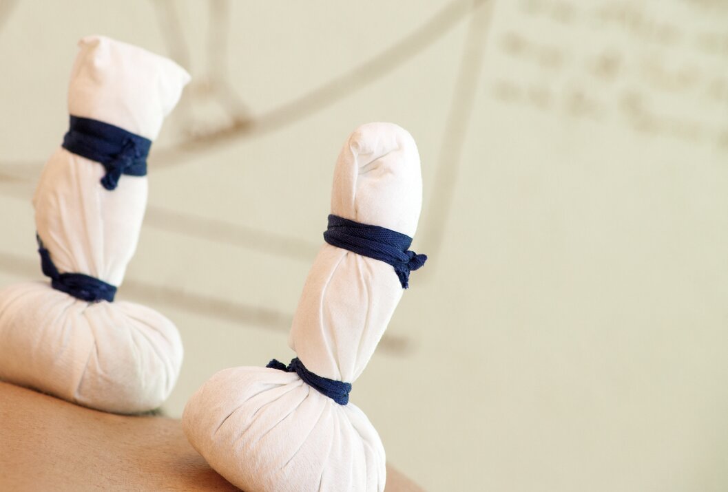 Zwei weiße Kräuterstempel mit blauen Bändern vor hellem Hintergrund