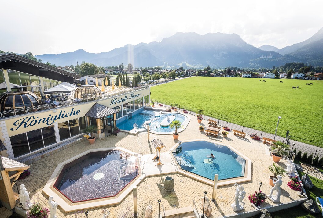Draufsicht auf Kristall Therme mit Pools, Liegen und grüner Landschaft im Hintergrund