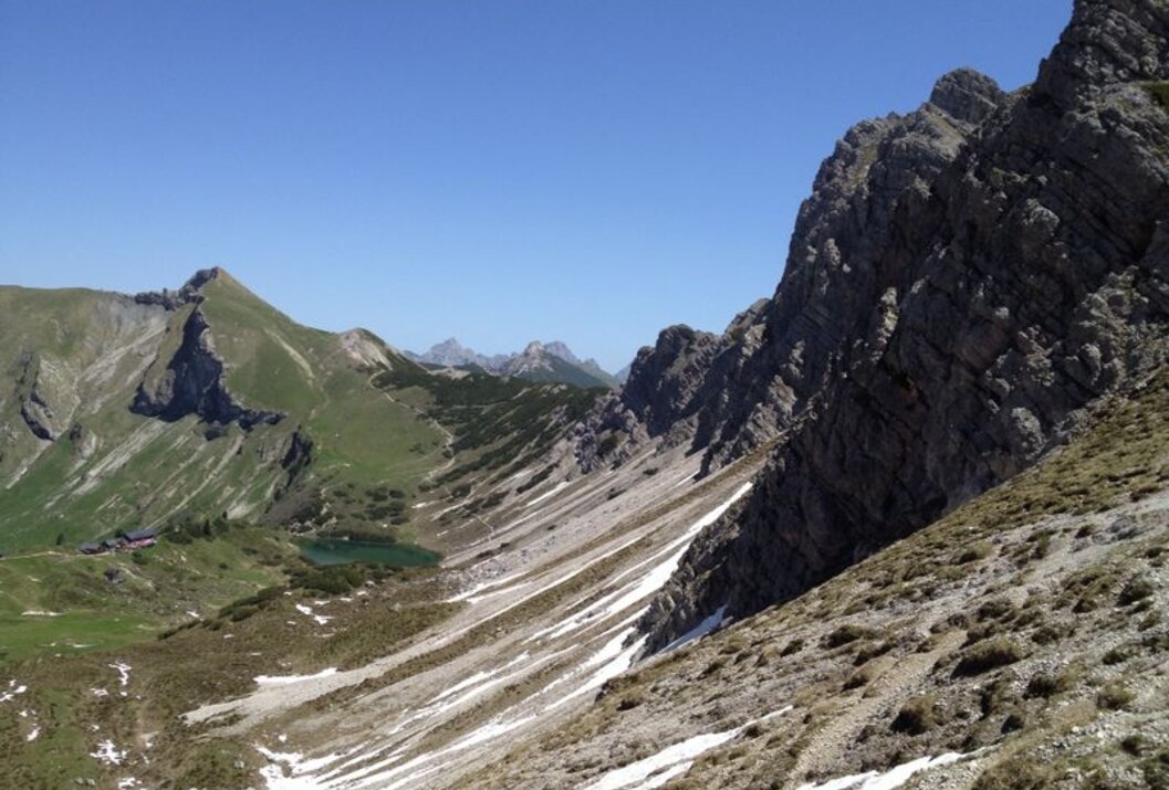 Berglandschaft mit See und Schnee unter blauem Himmel