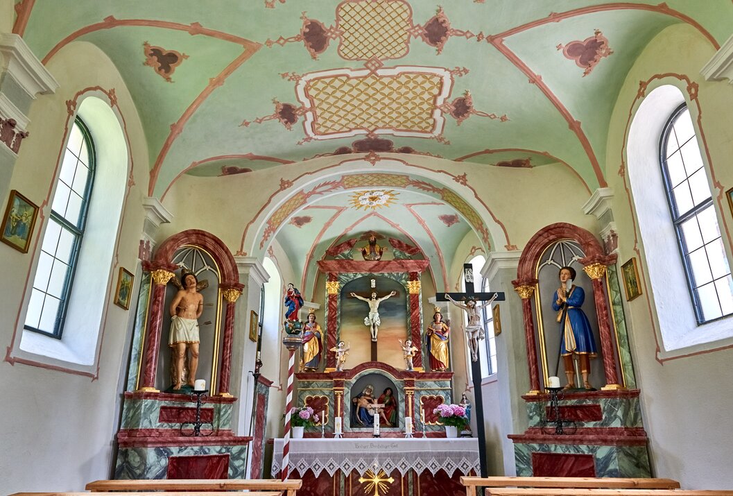 Innenansicht einer kleinen Kirche mit Altar, Statuen und Deckenmalerei