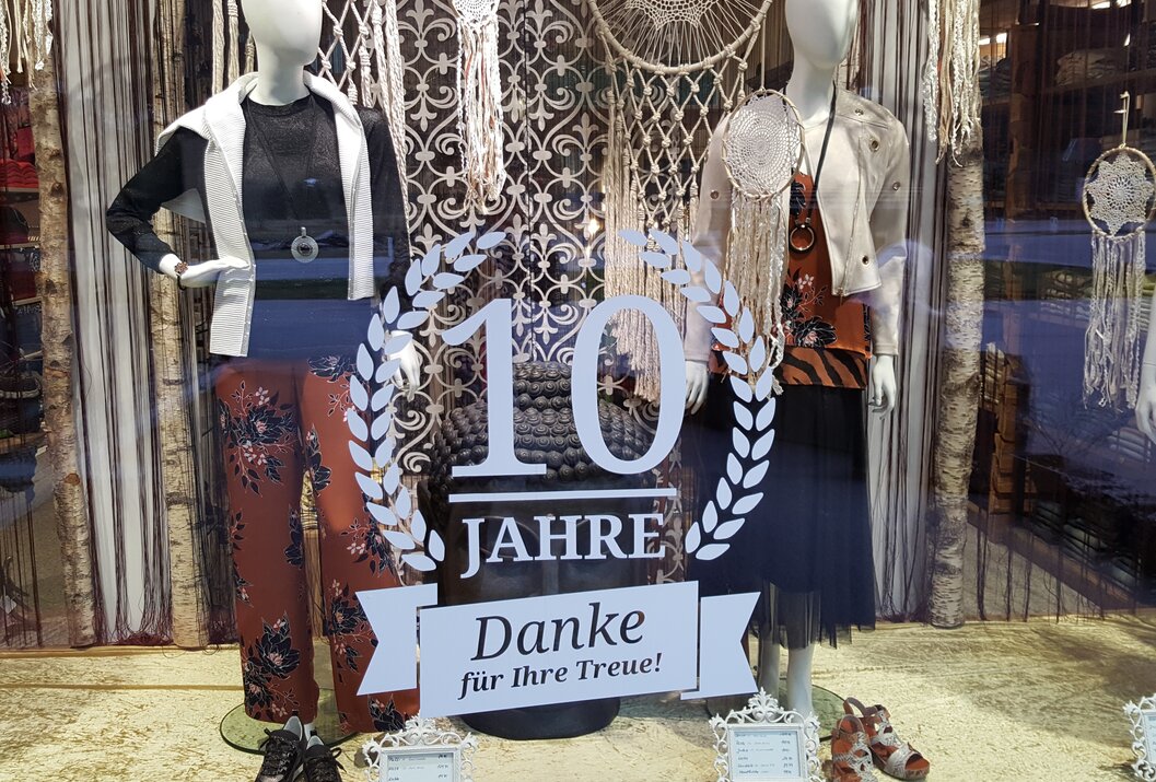 Shop window with two mannequins, clothing, decoration and sticker
