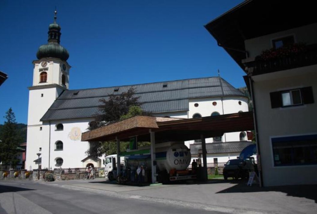 Tankstelle vor Kirche mit blauem Himmel