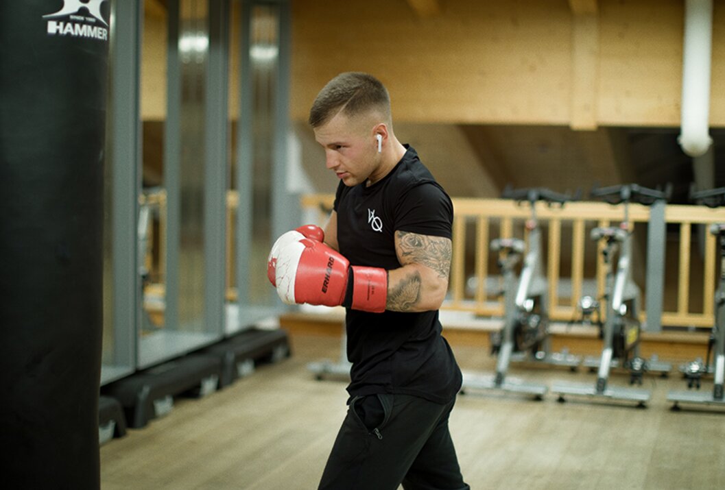 Man with boxing gloves and T-shirt training in the gym