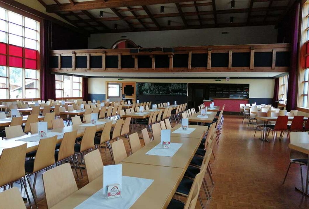 Großer Saal mit Tischen und Stühlen für eine Veranstaltung