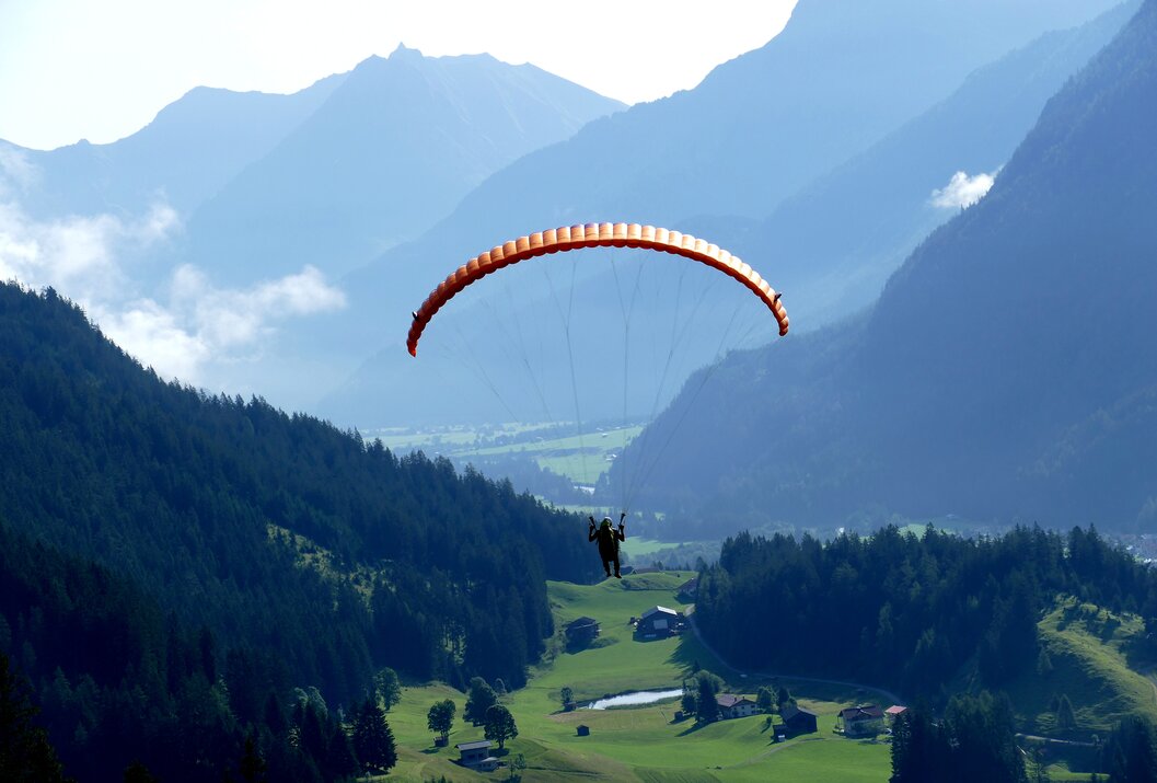 Gleitschirmflieger vor Berglandschaft