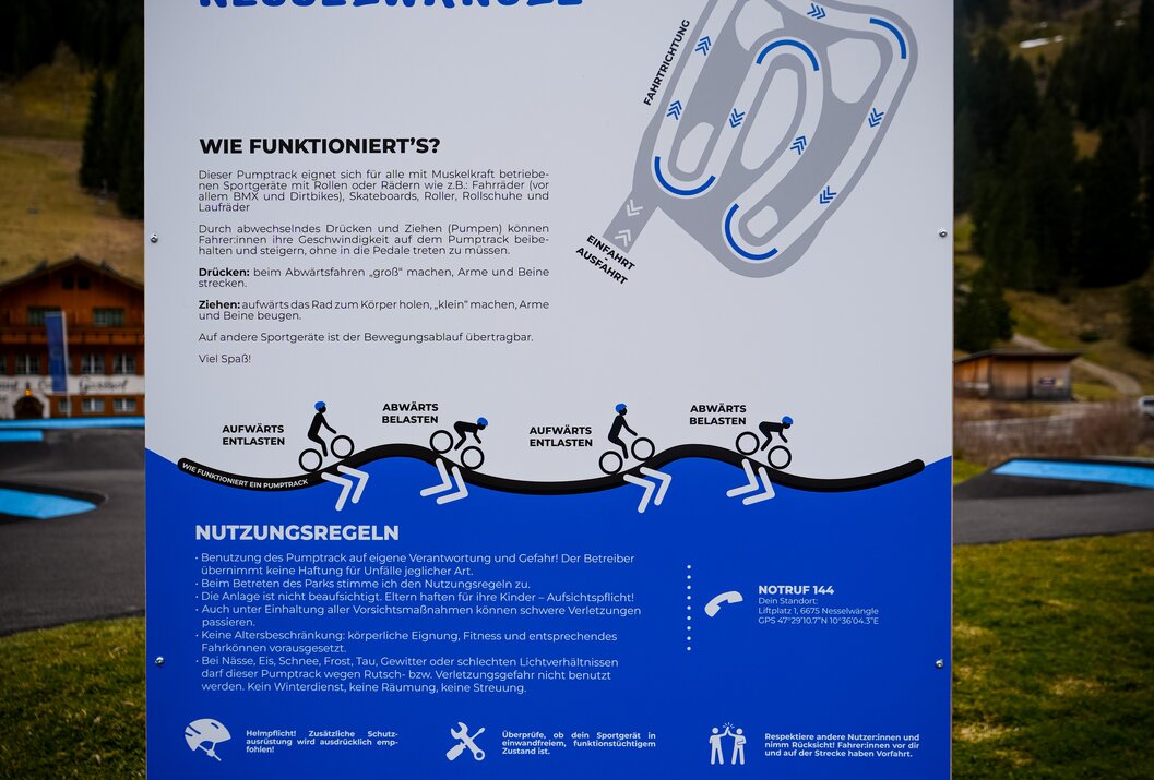 Infotafel Pumptrack Nesselwängle mit schematischer Darstellung und Nutzungsregeln vor Bergkulisse