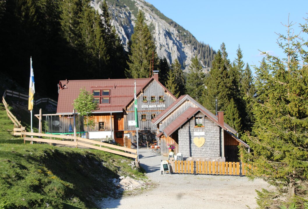 Hütte in den Bergen mit Bäumen und Felsen im Hintergrund