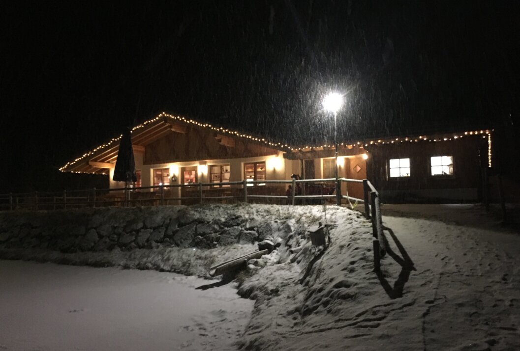 Beleuchtetes Gebäude bei Nacht im Schneetreiben