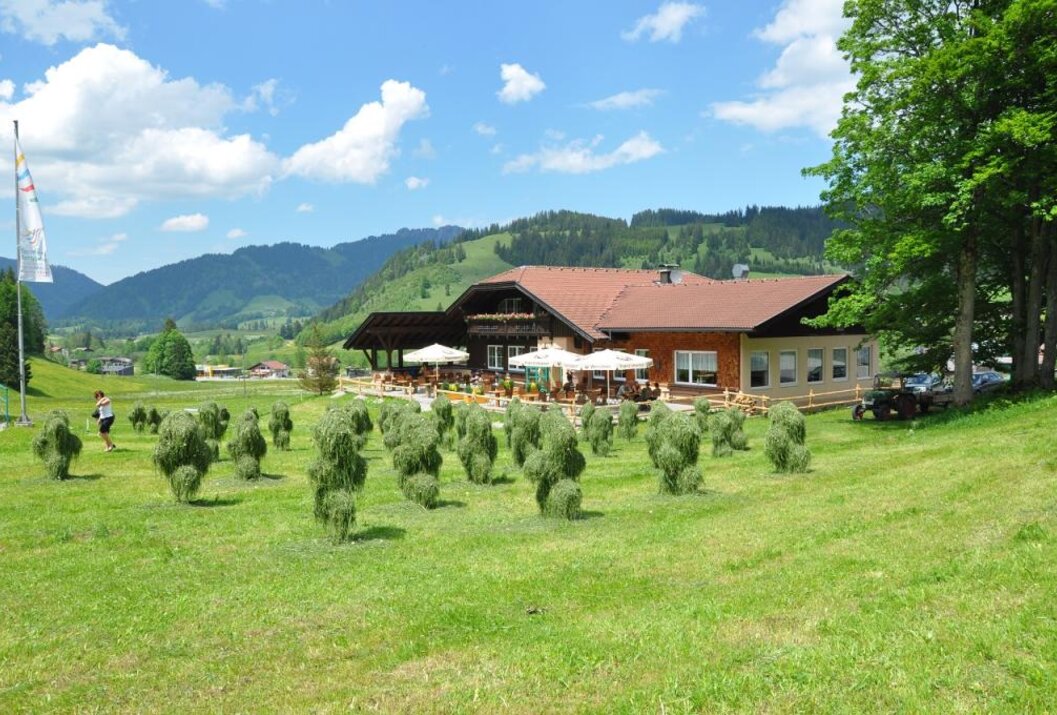 Alpine restaurant with terrace and hay bales on a meadow