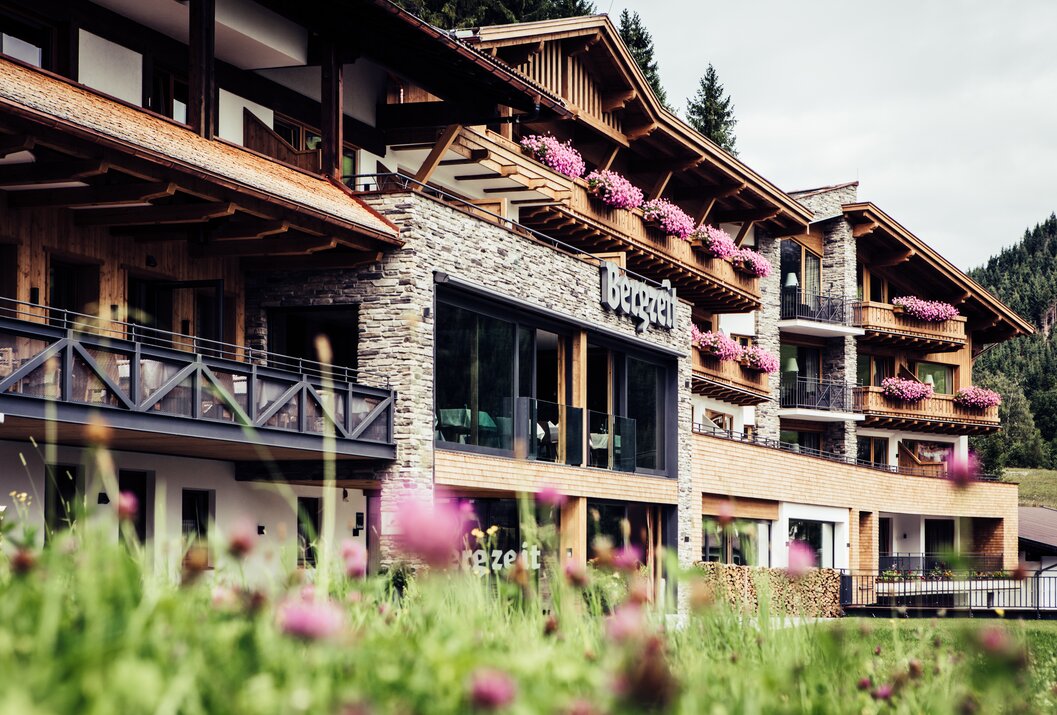 Alpines Hotelgebäude mit blühenden Balkonen im Gebirge