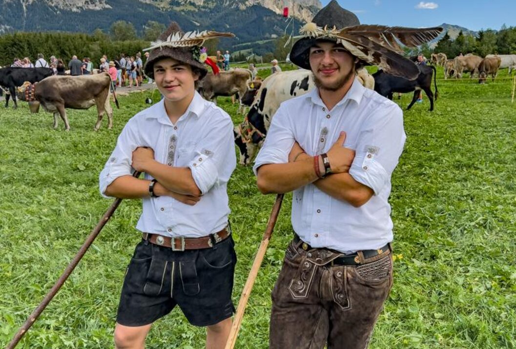 Young shepherds in traditional costume on an alpine meadow