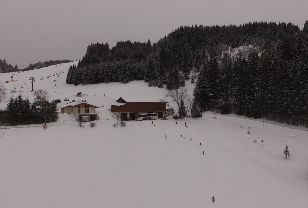 Verschneiter Skihang mit Liften und Gebäuden