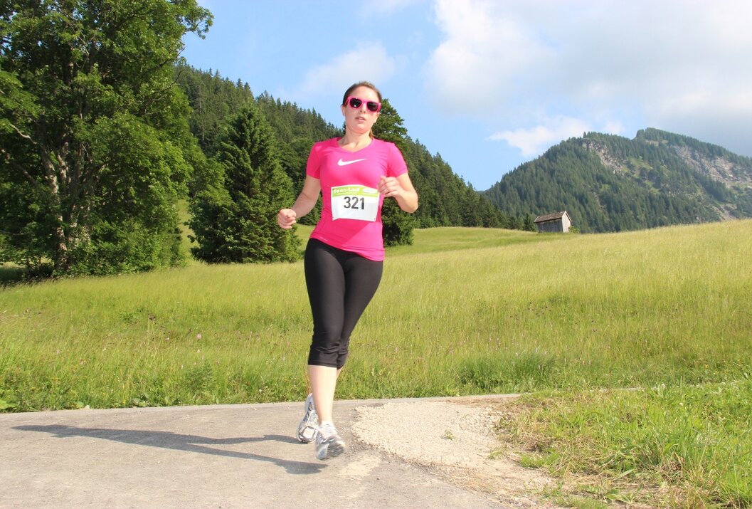Sportliche Läuferin auf sonniger Bergwiese